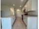 Open-concept kitchen featuring white cabinets, stainless steel appliances, and a spacious island with sink at 1212 Caloosa Ridge Ave, Babson Park, FL 33827