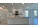Well-equipped kitchen with stainless steel appliances, white cabinetry, and a functional island with sink at 1212 Caloosa Ridge Ave, Babson Park, FL 33827