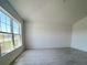 Bright living room with large windows, neutral walls and stylish gray tile flooring at 1212 Caloosa Ridge Ave, Babson Park, FL 33827