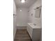 A well-lit bathroom features a bathtub, shower, sink, vanity, and wood-look flooring at 134 Daytona Ave, Daytona Beach, FL 32117