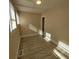 A cozy bedroom features wood-look floors, white trim, and natural light from the window at 134 Daytona Ave, Daytona Beach, FL 32117
