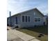 Charming one-story stucco home with a blue front door and a paved walkway at 134 Daytona Ave, Daytona Beach, FL 32117