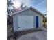 The detached garage has a white double door and a blue side entrance at 134 Daytona Ave, Daytona Beach, FL 32117
