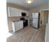 Well-lit kitchen features stainless steel appliances, white cabinets, and wood-look flooring at 134 Daytona Ave, Daytona Beach, FL 32117