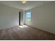 Inviting bedroom with plush carpeting, a window offering pleasant views, and neutral walls at 141 W 6Th St, Frostproof, FL 33843