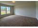 Bright bedroom with neutral carpet, a large window, and ample wall space for furnishings at 141 W 6Th St, Frostproof, FL 33843