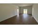 Spacious living room with wood-look tile flooring and a sliding glass door that fills the area with light at 141 W 6Th St, Frostproof, FL 33843