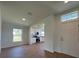 Bright living room featuring wood-look floors, a window, and an entry door with clerestory window and an open concept kitchen at 141 W 6Th St, Frostproof, FL 33843