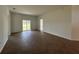 Large living room featuring wood-look tile flooring, ample natural light, and a sliding glass door at 141 W 6Th St, Frostproof, FL 33843