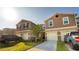 Inviting two-story townhome with attached garages, manicured lawn, and convenient driveway parking at 1412 Mirabella Cir, Davenport, FL 33897