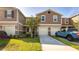 Inviting front exterior showcasing a two-story townhome with a garage and landscaped yard at 1412 Mirabella Cir, Davenport, FL 33897