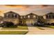 Charming townhomes with attached garages, well-manicured lawns and driveways on a sunny afternoon at 1412 Mirabella Cir, Davenport, FL 33897