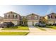Street view of the modern townhome with a well-manicured lawn, garage, and neutral exterior at 1412 Mirabella Cir, Davenport, FL 33897