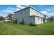 Side view of the home with a green, well-maintained lawn at 1447 Myrtle Oaks Trl, Oviedo, FL 32765