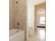 Bright bathroom featuring tiled shower-tub and archway leading to the primary bedroom at 1447 Myrtle Oaks Trl, Oviedo, FL 32765