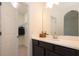 Bright bathroom featuring sleek vanity with solid surface countertop and walk-in closet at 1447 Myrtle Oaks Trl, Oviedo, FL 32765