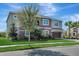 Two-story home featuring a two-car garage, landscaped front yard, and a combination of gray and brown exterior paint at 1447 Myrtle Oaks Trl, Oviedo, FL 32765