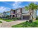 Beautiful two-story home with brick-paved driveway, lush lawn, and mature landscaping at 1447 Myrtle Oaks Trl, Oviedo, FL 32765