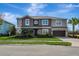 Two-story home featuring a manicured lawn, lush landscaping, and a two-car garage at 1447 Myrtle Oaks Trl, Oviedo, FL 32765