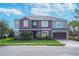 Charming two-story home with lush landscaping and a two-car garage and a green lawn at 1447 Myrtle Oaks Trl, Oviedo, FL 32765