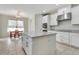 Bright kitchen features white cabinetry, a large center island, stainless appliances and tile flooring at 1447 Myrtle Oaks Trl, Oviedo, FL 32765