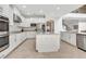 Well-lit kitchen features granite countertops, a center island, white cabinetry, tile flooring, and stainless appliances at 1447 Myrtle Oaks Trl, Oviedo, FL 32765