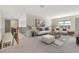 A spacious living room featuring neutral tones, large windows, and a cozy seating arrangement at 1447 Myrtle Oaks Trl, Oviedo, FL 32765