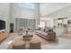 This bright, furnished living room features high ceilings, neutral carpet and decor and an open-concept design at 1447 Myrtle Oaks Trl, Oviedo, FL 32765