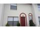 Two-story condo featuring a red door and a light-colored stucco exterior at 1617 Shady Ridge Ct # 257, Orlando, FL 32807