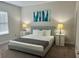 Comfortable bedroom with a large bed, stylish side tables, and modern art at 207 Aidans Lndg, Haines City, FL 33844