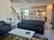 Open concept living room with modern furnishings, stairs and adjoining kitchen with breakfast bar at 207 Aidans Lndg, Haines City, FL 33844