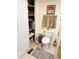 The bathroom features a toilet, towel rack and open closet for storage at 207 Jacaranda Dr, Leesburg, FL 34748
