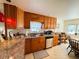 Bright kitchen with dark cabinets, stainless steel appliances, tile backsplash, and a charming breakfast table at 207 Jacaranda Dr, Leesburg, FL 34748