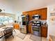 Well-equipped kitchen with stainless steel appliances, granite counters, and wood cabinetry at 207 Jacaranda Dr, Leesburg, FL 34748