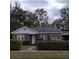 Charming brick home with a well-maintained lawn and mature trees, offering a cozy and inviting curb appeal at 225 E Cummings St, Lake Alfred, FL 33850