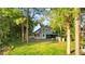 Picture of backyard featuring lush grass, mature trees, and screened in porch at 2449 E Lake Dr, Deland, FL 32724