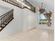 Bright living room featuring tile floors, a staircase, large windows, and elegant light fixtures at 2449 E Lake Dr, Deland, FL 32724