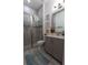 This bathroom features tile floors, a glass enclosed shower, grey vanity and a framed mirror at 25879 Crossings Bluff Ln, Sorrento, FL 32776
