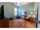 This bedroom features hardwood floors, an area rug, a window and blue colored walls at 25879 Crossings Bluff Ln, Sorrento, FL 32776