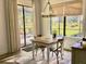 Bright breakfast nook features backyard view, modern chandelier, wood floors, neutral colors, and natural light at 25879 Crossings Bluff Ln, Sorrento, FL 32776
