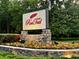 Stone RedTail community sign surrounded by colorful flowers and lush greenery welcomes residents and guests at 25879 Crossings Bluff Ln, Sorrento, FL 32776