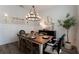 Well-lit dining room boasts stylish chandelier, seating for six, and bright wall art at 25879 Crossings Bluff Ln, Sorrento, FL 32776