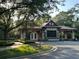 Elegant gated entrance with stone accents, landscaping, and a well-maintained road at 25879 Crossings Bluff Ln, Sorrento, FL 32776