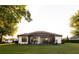 View of the back of the house with green lawn, screened porch, and mature trees at 25879 Crossings Bluff Ln, Sorrento, FL 32776