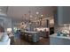Stylish kitchen with gray cabinetry, pendant lighting over a large island and hardwood floors at 25879 Crossings Bluff Ln, Sorrento, FL 32776