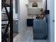 Functional laundry room boasts gray cabinets, countertop, shelving, modern appliances, and wood floors at 25879 Crossings Bluff Ln, Sorrento, FL 32776