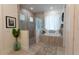 Bright bathroom features walk-in shower, soaking tub, gray tile, white curtains, and modern decor at 25879 Crossings Bluff Ln, Sorrento, FL 32776