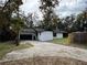 Charming home featuring a well-maintained lawn and long driveway leading to an attached two-car garage at 303 E Fountain St, Fruitland Park, FL 34731