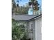 Exterior shot of home with a gray roof and white trim, complemented by surrounding trees and foliage at 309 Old Mission Rd, New Smyrna Beach, FL 32168