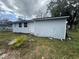 The exterior view showcases the side of the home with small windows and the white door at 309 Old Mission Rd, New Smyrna Beach, FL 32168